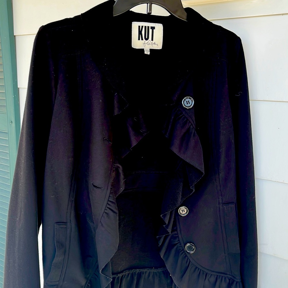 Black jacket with ruffles around sleeves and neck